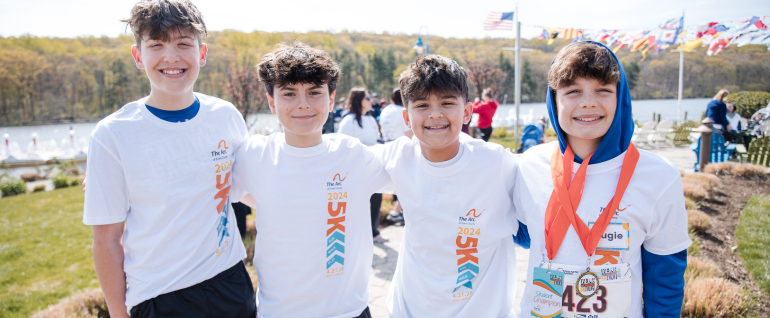 Four boys wearing Building Tomorrows 5K t-shirts at the South Mountain Recreation Complex Reservoir.