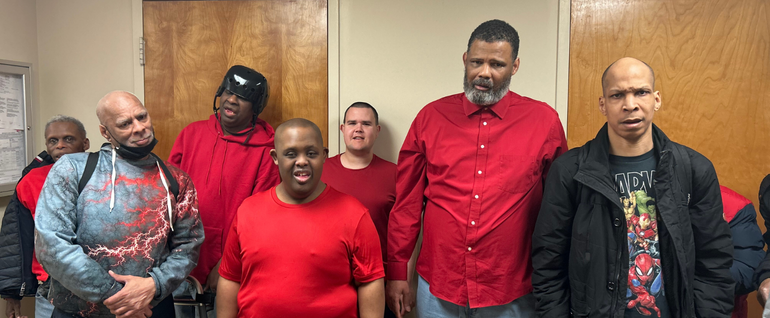 A group of seven men, most of them wearing red.