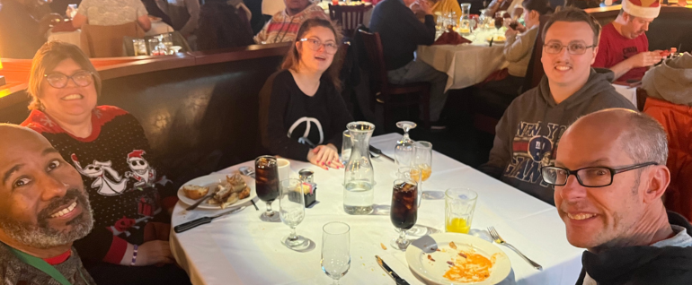 A group of five people sitting around a table at a restaurant.