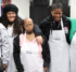 A group of five women stand together wearing white Studio Arc aprons.