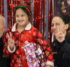 A girl in Christmas pajamas holding a wrapped gift and standing in between two police officers. All three are giving a peace sign.