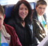 A woman sits in between two teenage boys in an airplane row on a United aircraft. The boys are wearing sunflower lanyards and their Wings for All t-shirts.