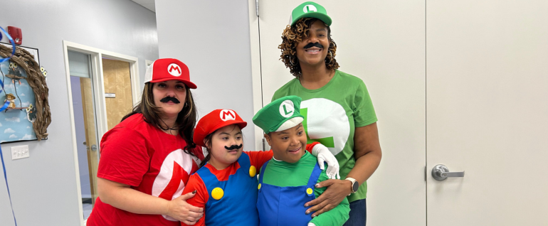 A mother and son dressed as Mario and a mother and son dressed as Luigi