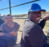 Four adults smiling and enjoying a hayride on a farm.