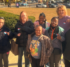 A group of seven people stand together, wearing "I Voted" stickers.