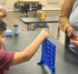 Two children playing Connect Four together at a table.