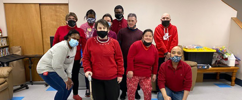 A group of 10 people gathered; most are wearing red.
